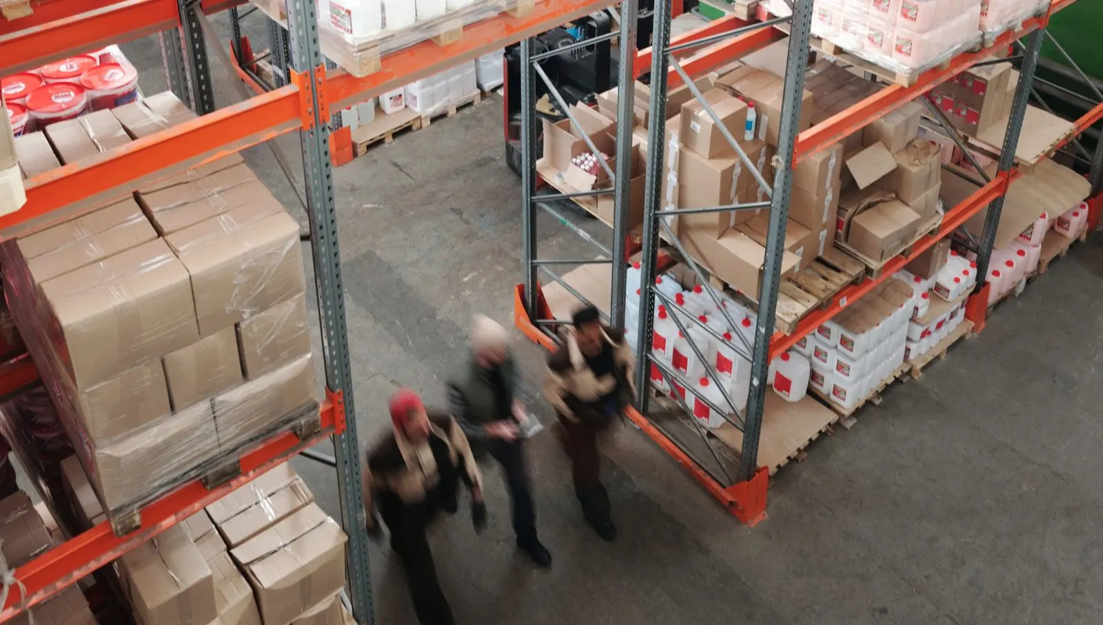 Distribution warehouse team moving between racking bays of multi-supplier stock